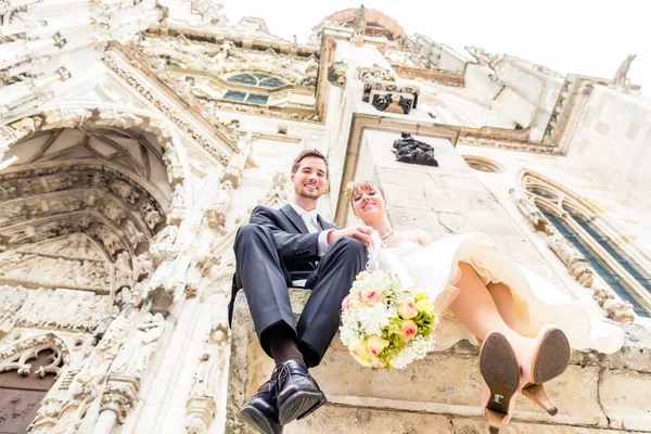 Couple nouvellement marié assis à l'extérieur de l'église — Photo