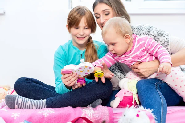 Syster och mor leker med baby — Stockfoto