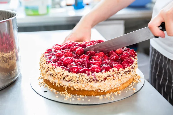 Close-up of woman confectioner cutting raspberry pie — Stock Photo, Image