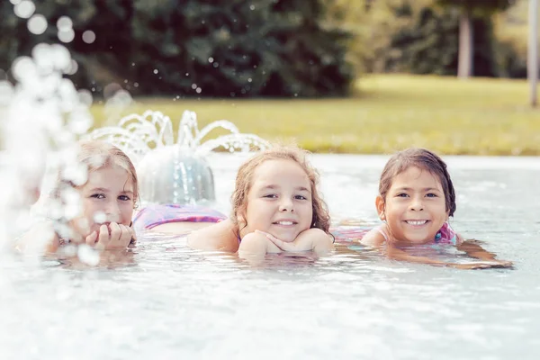 Маленькие девочки отдыхают в бассейне — стоковое фото