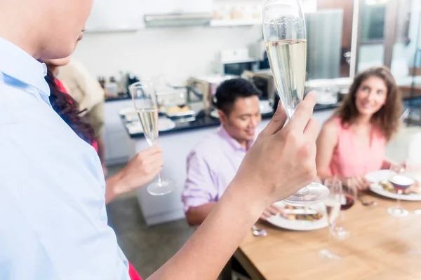 Hombre criando champagne tostada flauta con amigos — Foto de Stock