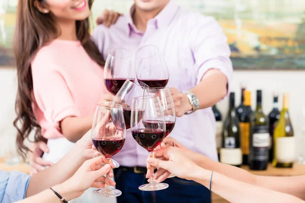 Casal brindar vinho tinto com amigos — Fotografia de Stock