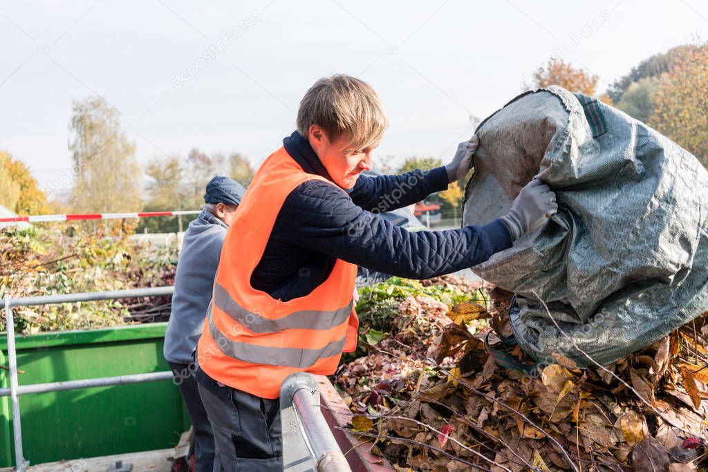 Man giving waste green in container on recycling center
