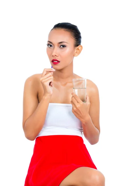 Donna che tiene il vetro di un'acqua e una pillola — Foto Stock