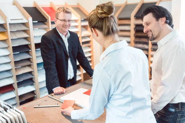 Mujer, hombre y experto discutiendo detalles del nuevo acabado de la cocina — Foto de Stock