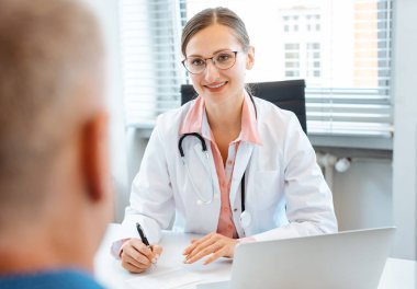 Doktor hastanın raporu üzerine notlar alma