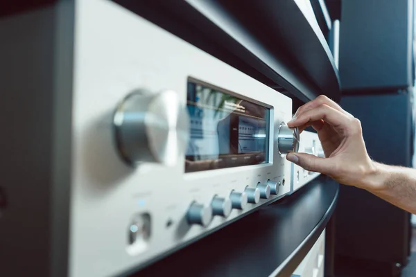 Hand einer Frau dreht Lautstärke des Hifi-Verstärkers hoch — Stockfoto