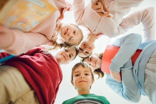 Schoolchildren and teacher looking down at the camera — Stock Photo, Image