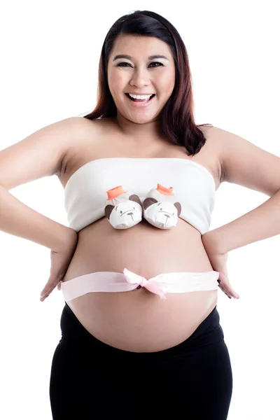 Těhotné ženské břicho s dětskou botou a mašlí — Stock fotografie