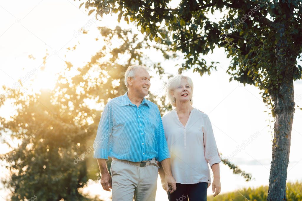 Senior woman and man having a walk along path in the countryside