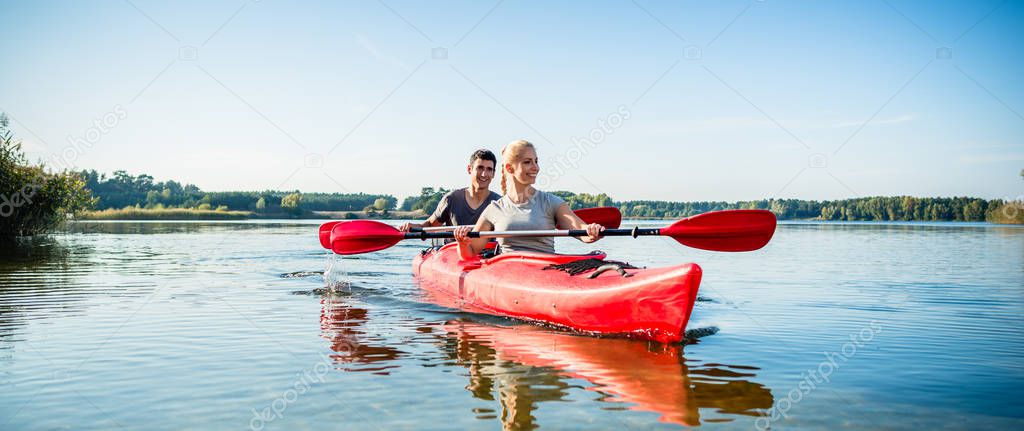 Happy couple kayaking on lake