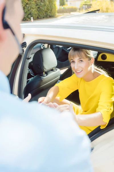 Taxikář pomáhající ženský pasažér z auta — Stock fotografie