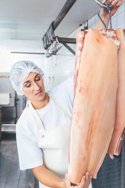 Mulher açougueiro corte de carne para uso posterior — Fotografia de Stock