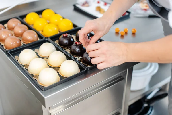 Patissier trabajando en pequeños postres de chocolate — Foto de Stock