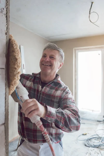 Plasterer alisamento parede interior de novas casas com máquina — Fotografia de Stock