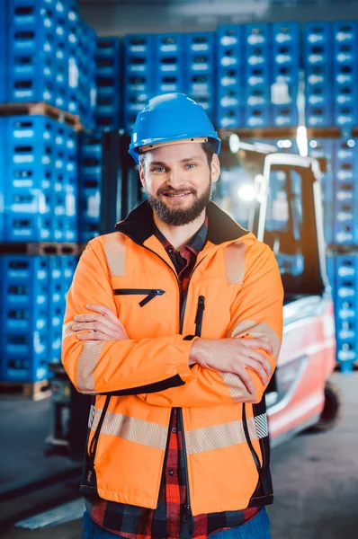 Trabalhador em uma empresa de encaminhamento com sua empilhadeira — Fotografia de Stock