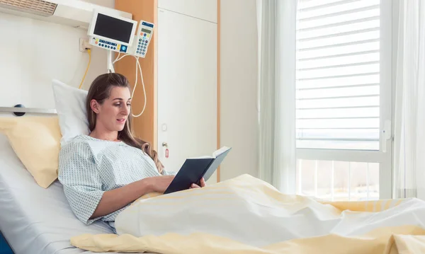 Frau liest im Krankenhausbett die Bibel — Stockfoto