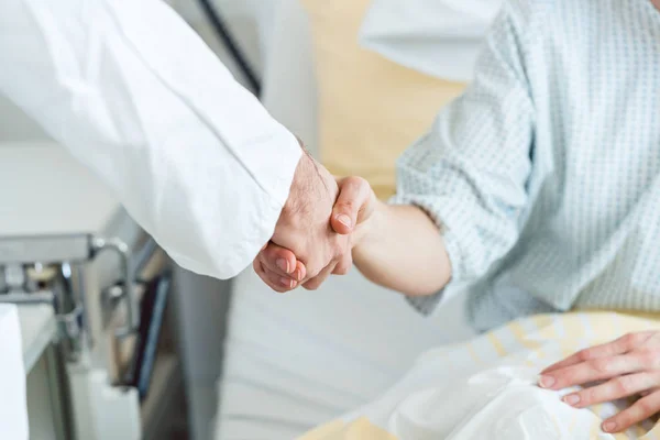 Doctor shaking hand of patient in hospital bed — Stock Photo, Image