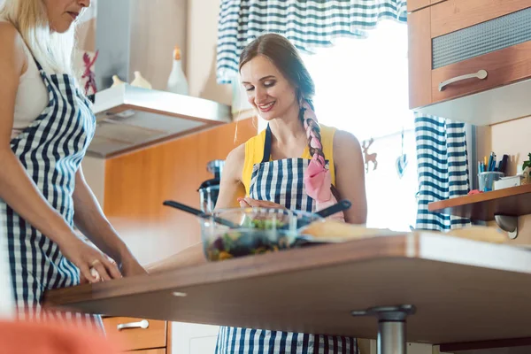 Två kvinnor förbereder rätter i köket — Stockfoto