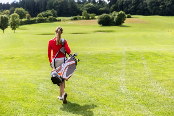 Vista trasera de la mujer que lleva bolsa de golf —  Fotos de Stock