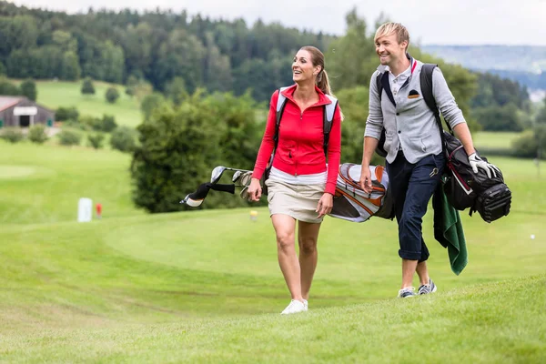 Casal de golfe andando juntos no campo de golfe — Fotografia de Stock