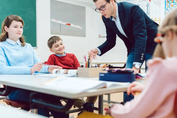 Alunos e professores que colaboram no exercício do trabalho em equipa — Fotografia de Stock