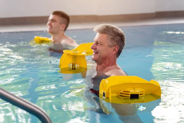 Personas en piscina durante la fisioterapia de gimnasia acuática — Foto de Stock