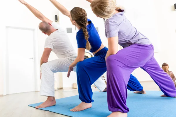 Gente deportiva realizando clases de yoga —  Fotos de Stock