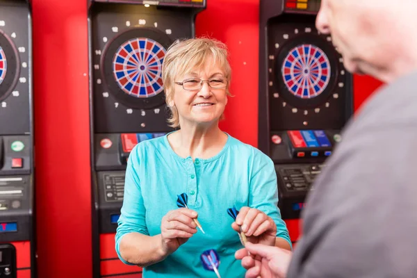 Volwassen vrouw houden dartbord pijlen — Stockfoto