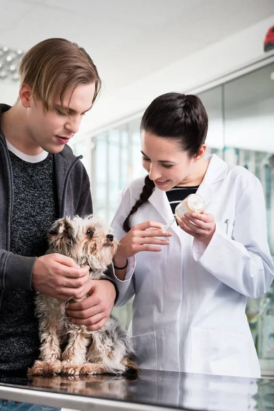 Veterinário feminino falando com cão doente — Fotografia de Stock