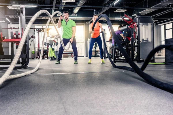 Kvinna och man Holding rep på gym — Stockfoto