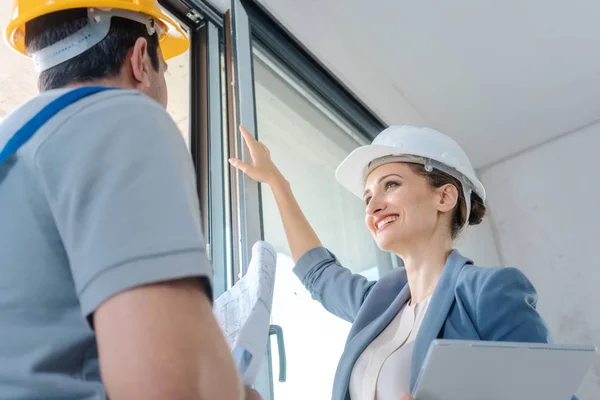 Architect and construction worker checking windows on site — Stock Photo, Image