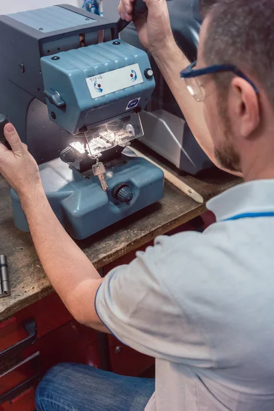 Cerrajero cortando la llave con su máquina — Foto de Stock