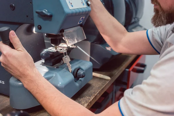 Cerrajero cortando la llave con su máquina — Foto de Stock