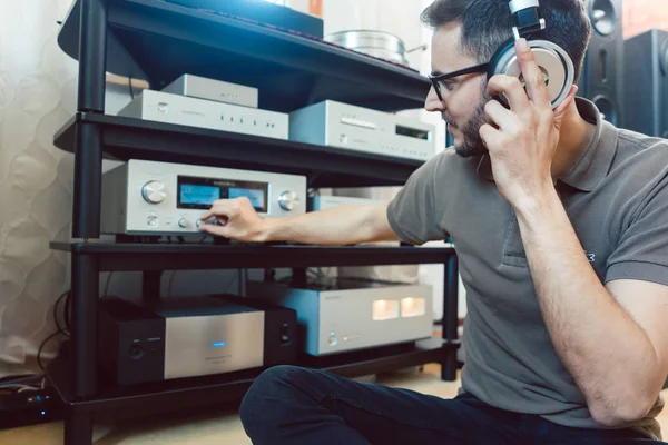 Man turning up the volume on home Hi-Fi stereo — Stock Photo, Image