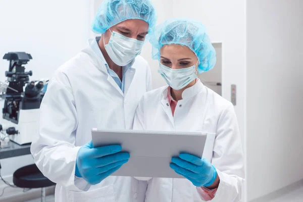 Dois cientistas trabalhando juntos em laboratório olhando para os dados — Fotografia de Stock