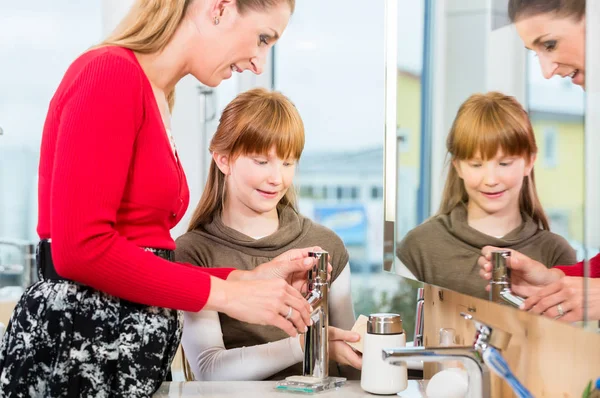 Woman checking a bathroom sink faucet in a modern sanitary ware shop — Stock Photo, Image