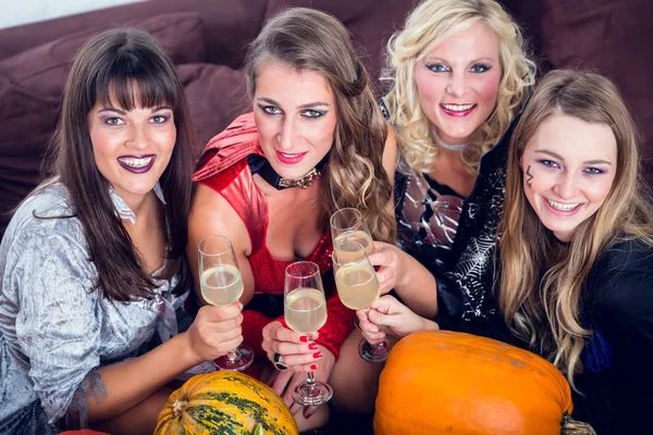Mujeres posando mientras brindan juntas durante la fiesta de Halloween —  Fotos de Stock