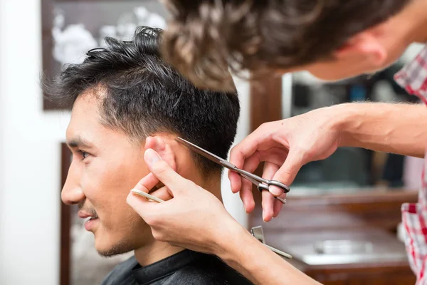 Barbeiro profissional aparar o cabelo dos clientes — Fotografia de Stock