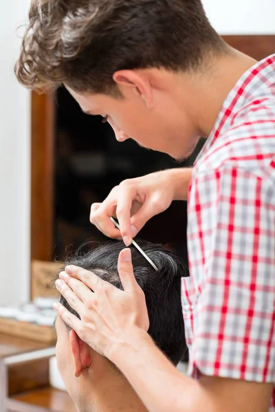 Peluquería peinando el cabello de los clientes —  Fotos de Stock