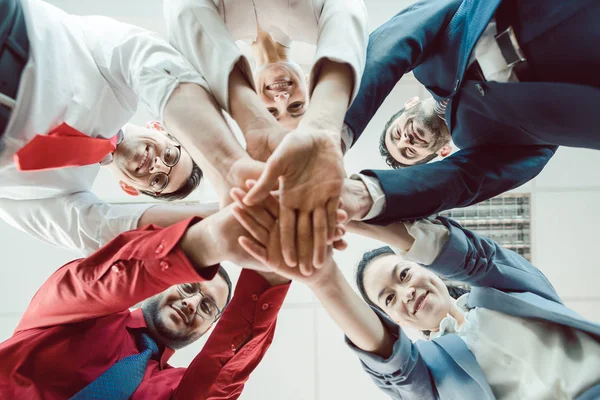 Team van diverse zakenmensen die hun handen samen stapelen — Stockfoto