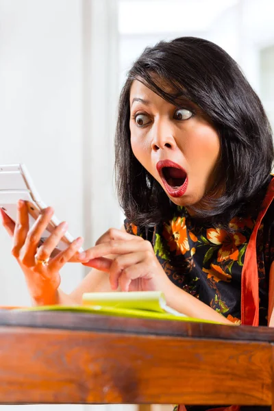 Σοκαρισμένος γυναίκα κοιτάζοντας αριθμομηχανή — Φωτογραφία Αρχείου