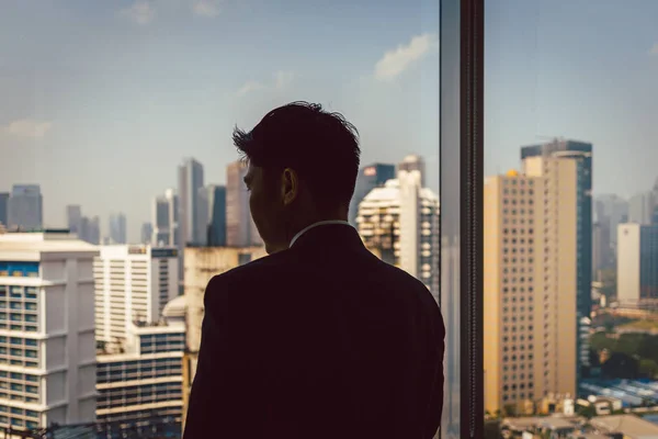 Businessman looking through window — Stock Photo, Image