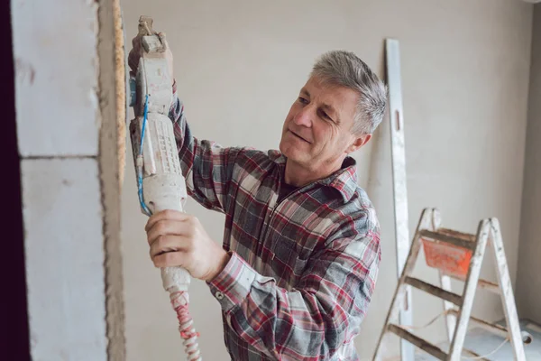 Plasterer alisamento parede interior com máquina — Fotografia de Stock