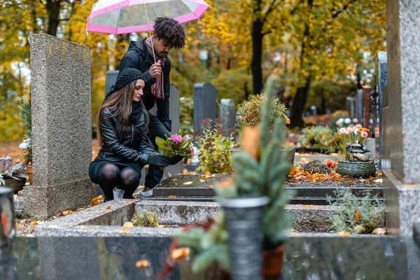 Casal na pena em um cemitério no outono — Fotografia de Stock