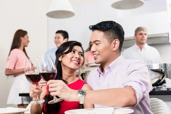 Улыбающаяся молодая пара пьет бокалы с вином — стоковое фото