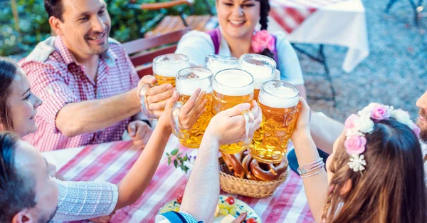 Pessoas que gostam de comida e bebida no jardim de cerveja da Baviera — Fotografia de Stock