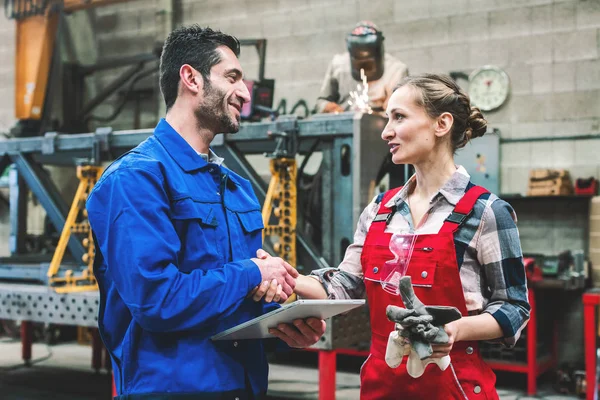 Arbetstagare i fabriken eller verkstad diskuterar projekt — Stockfoto