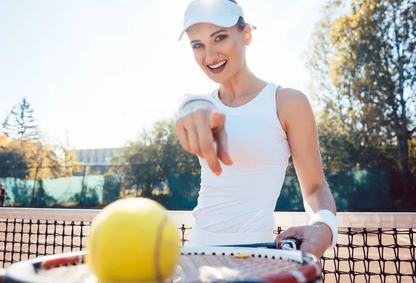 Egy nő a teniszpályán mutogatja a golyóit. — Stock Fotó