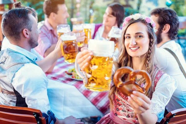 Vrouw toasten op de camera met glas bier in Beierse pub — Stockfoto